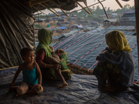 A Rohingya family sits inside their half built shelter in Balikhali refugee camp, Cox’s Bazar, Bangladesh. September 16, 2017. (