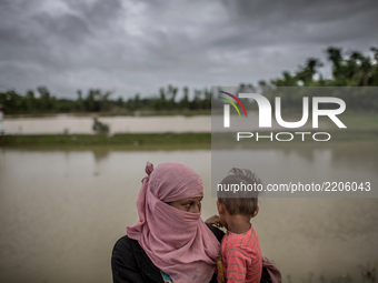 A Rohingya mother waits beside the road for relief with her kid. Balukhali, Cox’s Bazar, Chittagong, Bangladesh. September 19, 2017. (