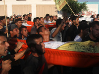  	People bury the bodies of three Palestinian boys from the Juda family and their mother, whom medics said were killed in an Israeli air str...