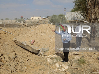RAFAH, GAZA STRIP, PALESTINE - AUGUST 25: A member of the Palestinian security forces (L) inspects the damage from an Israeli air strike at...