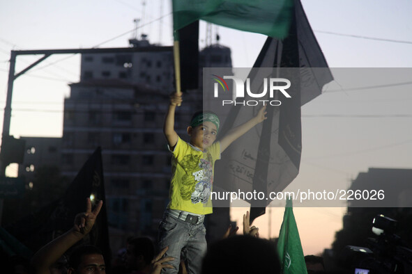 A Palestinian waves a Hamas flag (R) as others celebrate what they said was a victory over Israel, following a ceasefire in Gaza City August...