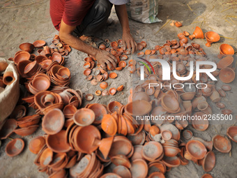 A Nepalese people collecting clay pot lamps after puts in a firing place after being sun dried for upcoming Tihar or Deepawali Festival on h...