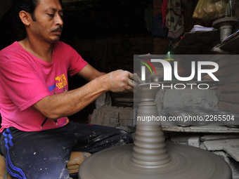 A Nepalese artist making clay pot lamps for upcoming Tihar or Deepawali Festival on his workshop at Pottery Square, Bhaktapur, Nepal on Mond...