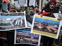 Palestinians shout slogans and wave flags, in front of the US Embassy, as they held a demonstration against the US president's Donald Trump...