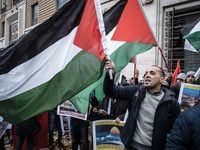 Palestinians shout slogans and wave flags, in front of the US Embassy, as they held a demonstration against the US president's Donald Trump...