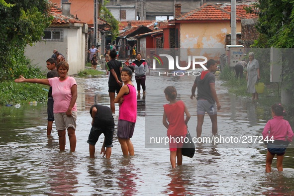 People try to cross flooded street and to save belongings after a heavy flood near the town of Burgas. Heavy rain and storm hit the Black se...