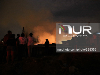 Residents look on as a major fire hits a slum located in the Campo Belo neighborhood on the Journalista Roberto Marinho Avenue in the south...