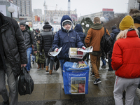 A woman is seen handing out free newspapers in central Warsaw on February 8, 2018. (