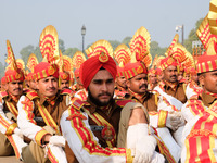 Sashastra Seema Bal (SSB) soldiers stretch while sitting on Rajpath during their rehearsal for the Republic Day parade on a winter morning i...