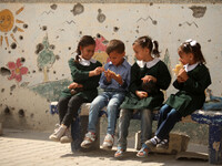 Palestinian students sit inside their school that witnesses said was shelled by Israel during its offensive, on the The second  day of the n...
