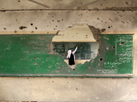 A Palestinian student Writing on the blackboard  inside a classroom that witnesses said was shelled by Israel during its offensive, on the s...