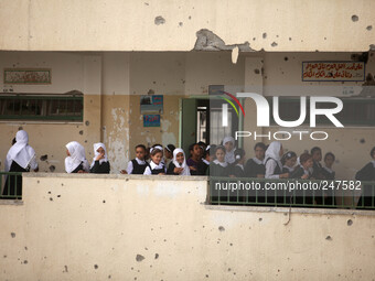 Palestinian students walk to their classrooms in their school that witnesses said was shelled by Israel during its offensive, on the The sec...