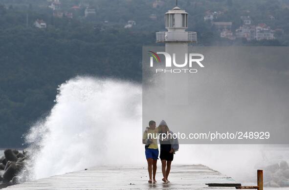 People enjoy the strong wind ang hight sea waves at the Black sea port of Varna east of the Bulgarian capital Sofia, Tuesday, Sep. 16, 2014....