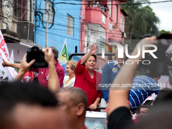 Brazil's President Dilma Rousseff (c) who is presidential candidate for the Workers Party (PT) waves to her supporters during a rally of her...