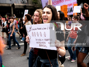 A woman holds a banner which reads 'One woman dies every two days due to unsafe abortions in Brazil' during a demonstration in favor of the...