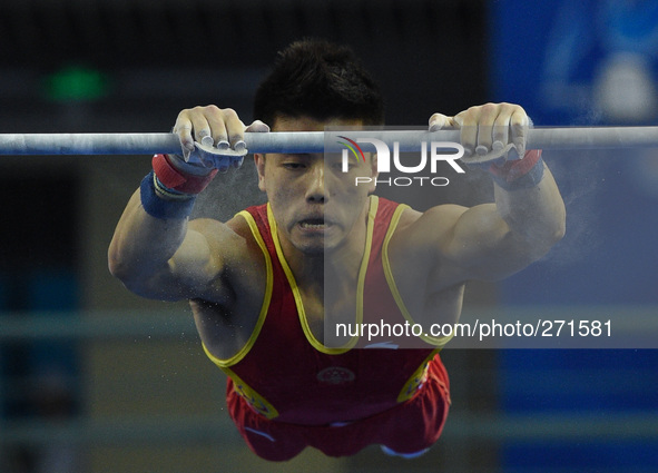 (141003) -- NANNING, Oct. 3, 2014 () -- Lin Chaopan from China performs on the horizontal bar during the men's qualifying round of the 45th...