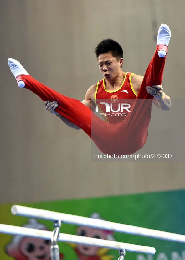 (141003) -- NANNING, Oct. 3, 2014 () -- Cheng Ran from China performs on the parallel bars during the men's qualifying round of the 45th Gya...