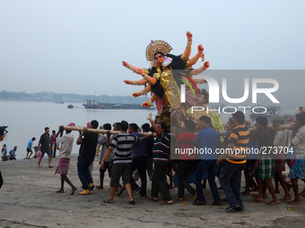 Indian labours carry an idol of Durga before immersion in the River Ganges on on the last day of Durga Puja  Festival (October 4, 2014)  in...