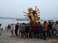 Indian labours carry an idol of Durga before immersion in the River Ganges on on the last day of Durga Puja  Festival (October 4, 2014)  in...