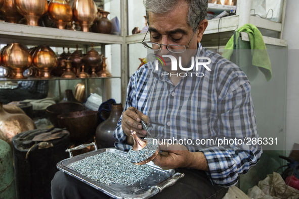 Artist sets mina stones for minakari, unique art of Esfahan, which means decorating metals with colorful and baked coats, Esfahan, Iran
