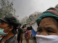 Sinabung volcano refugees scrambled to protect themselves from the thick volcanic ash following the recent eruption of Mount Sinabung in Tea...