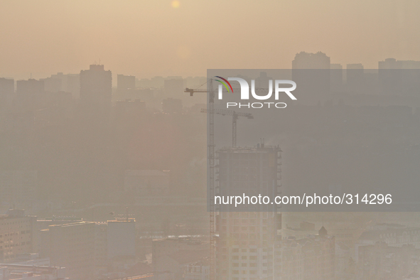 KIEV, UKRAINE - OCTOBER 30: The strong smoke is seeing as the sun sets over the Kiev city buildings. Peatlands have been burnt on the northe...