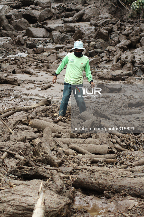 A man walked among the stones of cold lava eruption of Mount Sinabung has been eroding for landslide threatens villages Mardinding, Karo, Su...