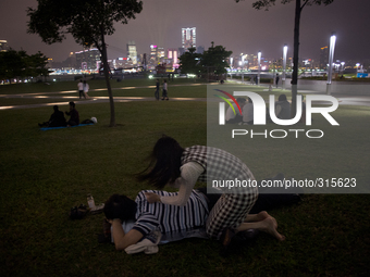 28th of October, 2015. Hong Kong, Hong Kong island, Admiralty. A couple relaxing and giving back massage by Tamar Park, area occupied by the...