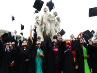 A group of graduates expressing their delight in front of the sculpture Raju at TSC area, on the 51th convocation of the students of Dhaka U...