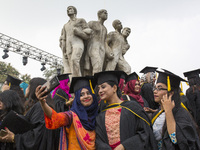 A group of graduates expressing their delight in front of the sculpture Raju at TSC area, on the 51th convocation of the students of Dhaka U...
