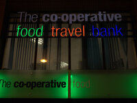 The colours of The Co-Operative group shining from a store, in central Manchester, through the late autumn darkness. (
