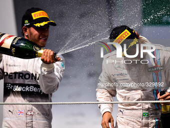 Mercedes AMG Petronas driver British Lewis Hamilton (L) celebrates his second place next to third place Brazil's Felipe Massa for Williams,...