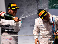Mercedes AMG Petronas driver British Lewis Hamilton (L) celebrates his second place next to third place Brazil's Felipe Massa for Williams,...