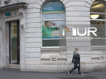 A woman walking on the street, as she passes the HBL bank in central Manchester. (