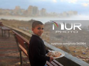  A Palestinian child seller at the shore of the sea in Gaza City, which is experiencing low pressure and rain. (