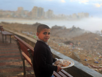 A Palestinian child seller at the shore of the sea in Gaza City, which is experiencing low pressure and rain. (