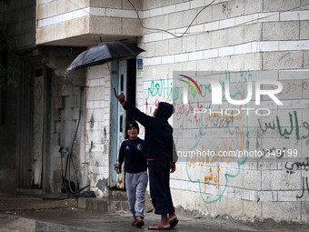 Children sitting on the door of their house during a rainfall on Gaza with the start of a very low air hits Palestine, on November 25, 2014....