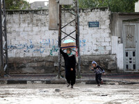 woman walks the street during rain 'has hit Gaza very low in the past 3 days and so far(