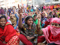 Bangladeshi garment workers shout slogans as they block a road during a demonstration to demand higher wages, in Dhaka on January 9, 2019....