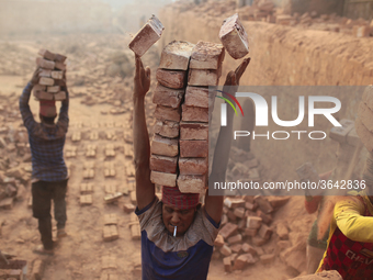 A man stacks more than a dozen bricks on his head while working at in brickfields Narayanganj near Dhaka Bangladesh on January 12, 2019. (