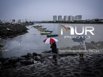 Pasay City City Philippines - Women prepare to evacuate in Manila Bay as Typhoon Hagupit (locally known as Ruby) approaches Manila on Monday...