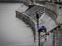 Makati City, Philippines - Men fish by the river in Makati City despite warnings from local government officials as Typhoon Hagupit (locally...