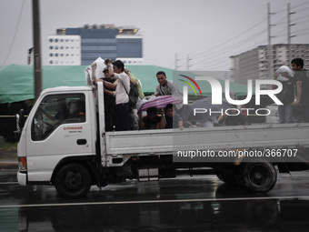 Pasay City, Philippines - Men ride a truck on their way home as Typhoon Hagupit (locally known as Ruby) approaches Manila on Monday, Decembe...