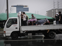 Pasay City, Philippines - Men ride a truck on their way home as Typhoon Hagupit (locally known as Ruby) approaches Manila on Monday, Decembe...