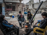 A group of rebels sit around the fireplace, in Aleppo, Syria, on December 13, 2014.  (