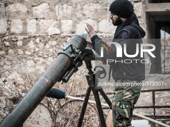 One of the rebels put the mortar shell inside cannon, in Aleppo, Syria, on December 13, 2014.  (