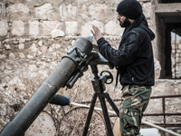 One of the rebels put the mortar shell inside cannon, in Aleppo, Syria, on December 13, 2014.  (