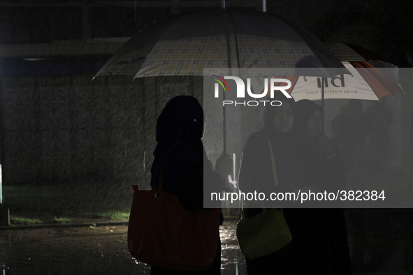 Acehnese women use umbrellas for them to pray for victims of the tsunami disaster ahead of the 10th anniversary in Baiturrahman Grand Mosque...