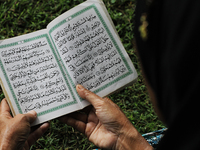 Acehnese woman holding Al-Quran when he read a prayer for friends and families of those killed by the Indian Ocean tsunami hit Aceh in a mas...