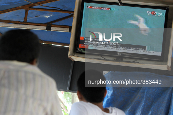 Indonesian people watching area locations allegedly found fragments airline Air Asia flight lost QZ 8501 as shown in one of the local televi...